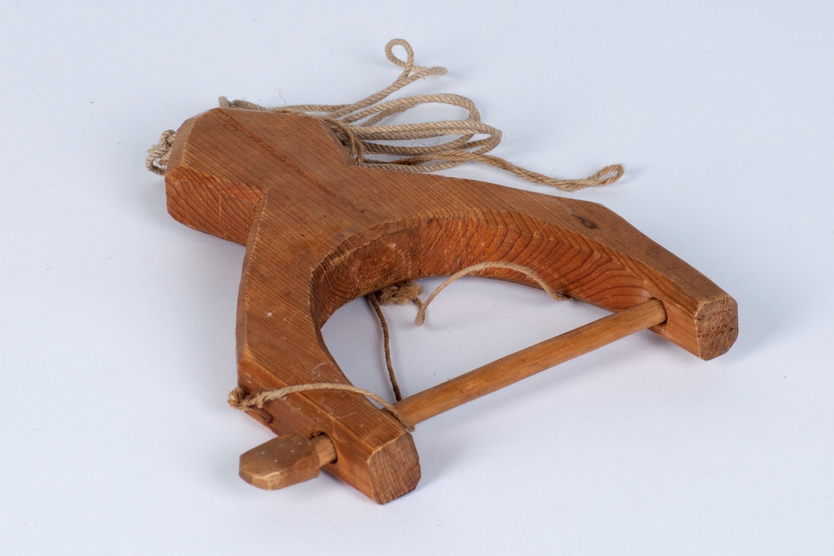 Et trestykke med et hull i den ene enden hvor det er festet en tråd til oppheng under arbeidet. Den andre enden består av en trepinne som går gjennom to hull. Den er til å låse av garnet der man sitter og binder nye masker/stolper.