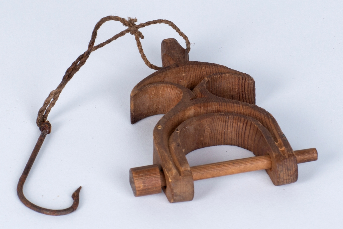 Et trestykke med et hull i den ene enden hvor det er festet en tråd med krok i. Den andre enden består av en trepinne som går gjennom to hull. Den er til å låse av garnet der man sitter og binder nye masker/stolper.