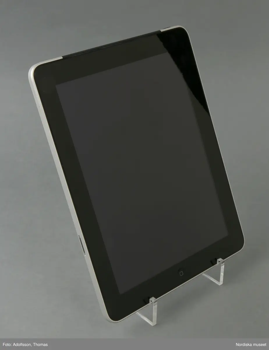 iPad 64 GB. En platt beröringskänslig glasskärm . I skärmen syns en svart bred ram infärgad i glaset, Denna ram inramar bildytan på skärmen. På skärmens nedre del finns en rund grop (ca 1 cm diam) vilken är iPadens hemknapp.
iPadens på/av-knapp är placerad på höger sidas övre kant. Utmed högra långsidans kant finns ljudets på/av-knapp följd av volumknappen. På den nedre kanten finns dels högtalarna och dels uttag för uppladdning av IPadens batteri.   
Baksidan på IPaden är täckt av ett aluminiumhölje som döljer och skyddar tekniken.
När iPaden startar tänds skärmens bildyta upp med LED-ljus. Därefter är det bara att börja "surfa".

/Cecilia Wallquist 2019-01-30
