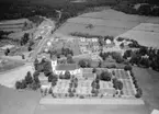 Flygfoto över Hässleby i förgrunden ser man Hässleby kyrka i Eksjö kommun, Jönköpings län. 754/1964