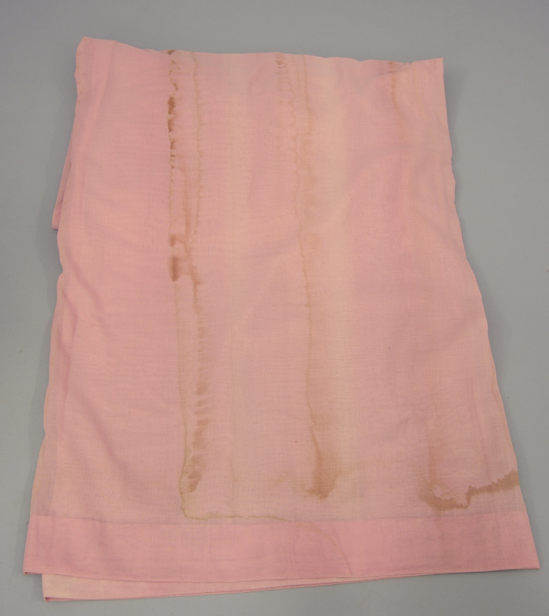 Gardin med kappe og stores. Rødorange gardin i bomull og syntetiskematerialer. Gardinen er fòret med beige bomullstøy. Gardinkappe i samme materiale. Rosa stores i bomull. Gardinen har hengt i spisesalen på Ulefos Hovedgaard.