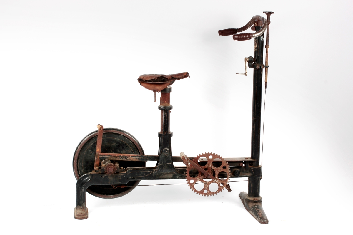 Krummet styre m/gummiholker på rett stang. Foran stanga kort stolpe m/skrue og ledning. På stanga sveiv m/tannhjul. Nederst horisontal jernstolpe med pedaler, tannhjul og hjul m/DI 41 cm Sykkelen står på 2 føtter, den fremste bredere enn den bak. Tidl. reg.: "Sirkus Direktør Carl Norbecks Mosjons Sykkel. Ut- lånt av Ullensaker Kisa Idrettslag 1961" Om Karl Norbeck, se to avisutklipp, det ene datert 5/11 1962.

A: Mosjonssykkel
B: Løse gummihåndtak, 2 stk.