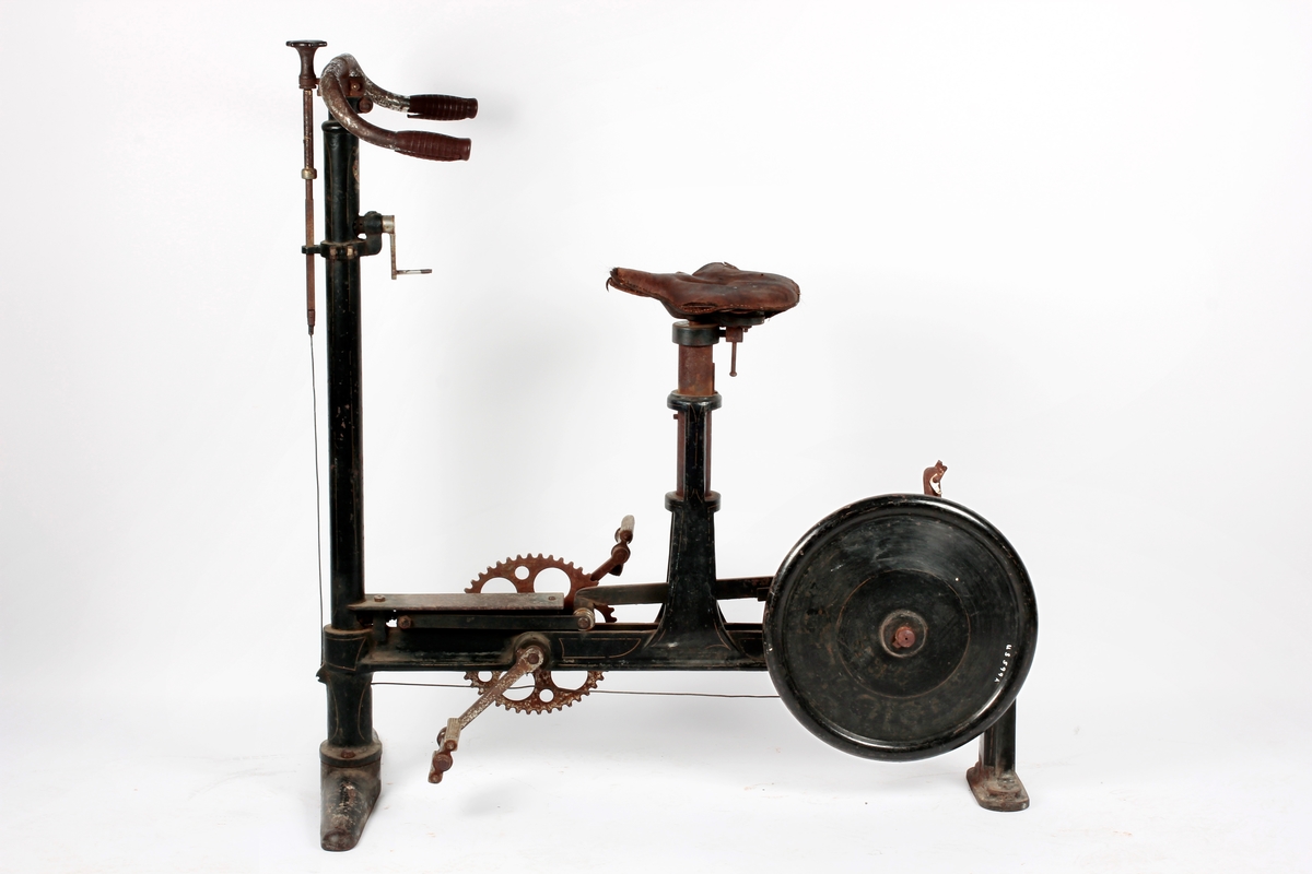 Krummet styre m/gummiholker på rett stang. Foran stanga kort stolpe m/skrue og ledning. På stanga sveiv m/tannhjul. Nederst horisontal jernstolpe med pedaler, tannhjul og hjul m/DI 41 cm Sykkelen står på 2 føtter, den fremste bredere enn den bak. Tidl. reg.: "Sirkus Direktør Carl Norbecks Mosjons Sykkel. Ut- lånt av Ullensaker Kisa Idrettslag 1961" Om Karl Norbeck, se to avisutklipp, det ene datert 5/11 1962.

A: Mosjonssykkel
B: Løse gummihåndtak, 2 stk.