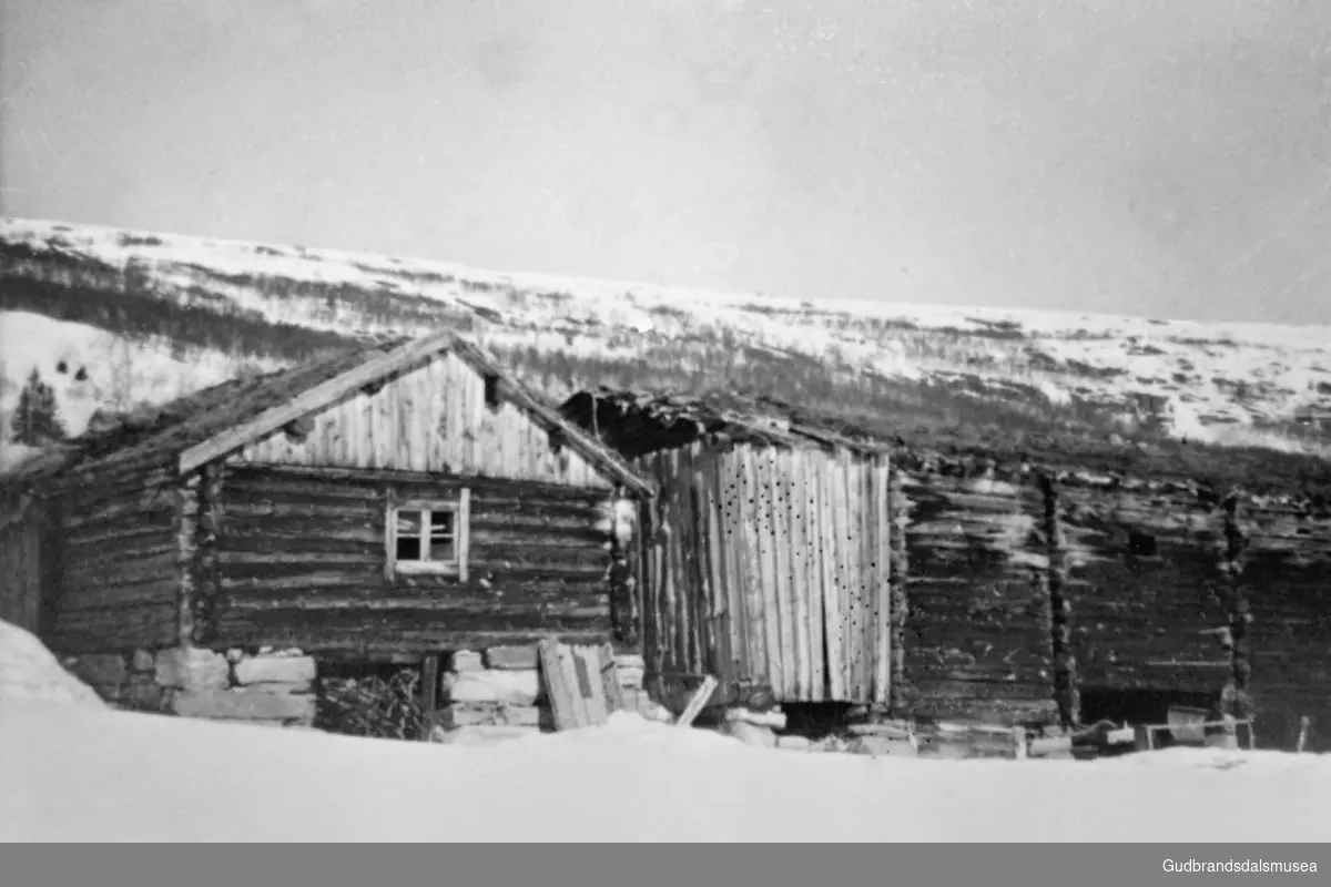 To bygninger, fjøs og stall i Øvre Kvean, det er vinter. 