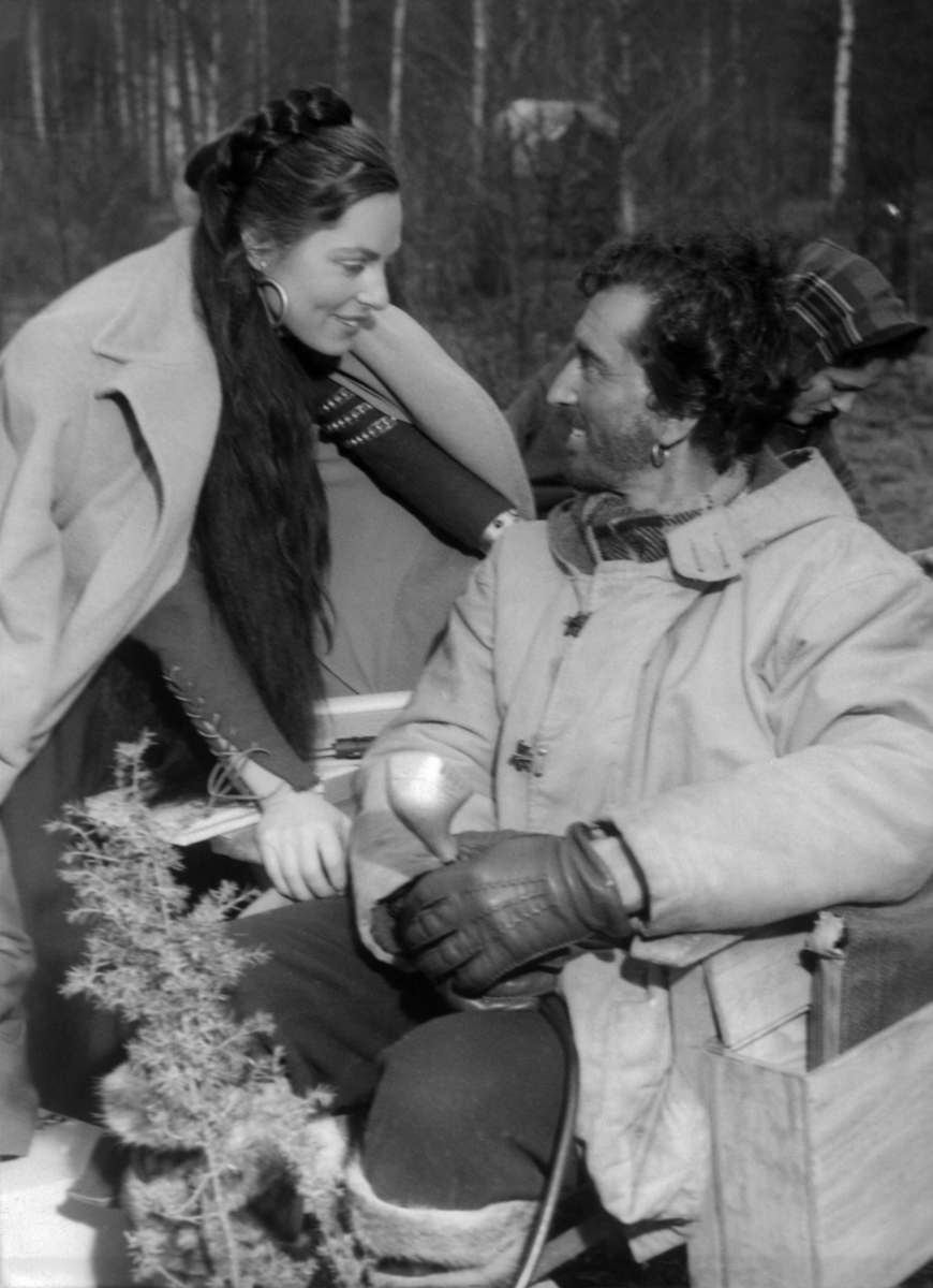 Fotografi taget vid inspelning av filmen Singoalla, Viveca Lindfors som spelade rollen som Singoalla och Lauritz Falk, tolk och inspelningsledare, syns i bild. Viveca står lutad över en stol där Lauritz sitter.