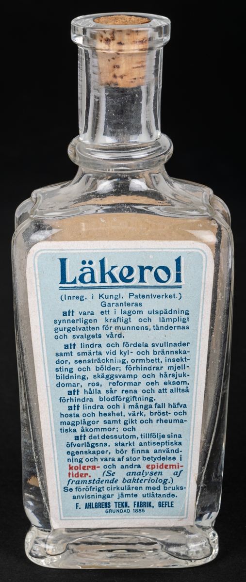 Glasflaska med kork, har innehållit anticeptiskt medel. Text bl.a: "LÄKEROL"