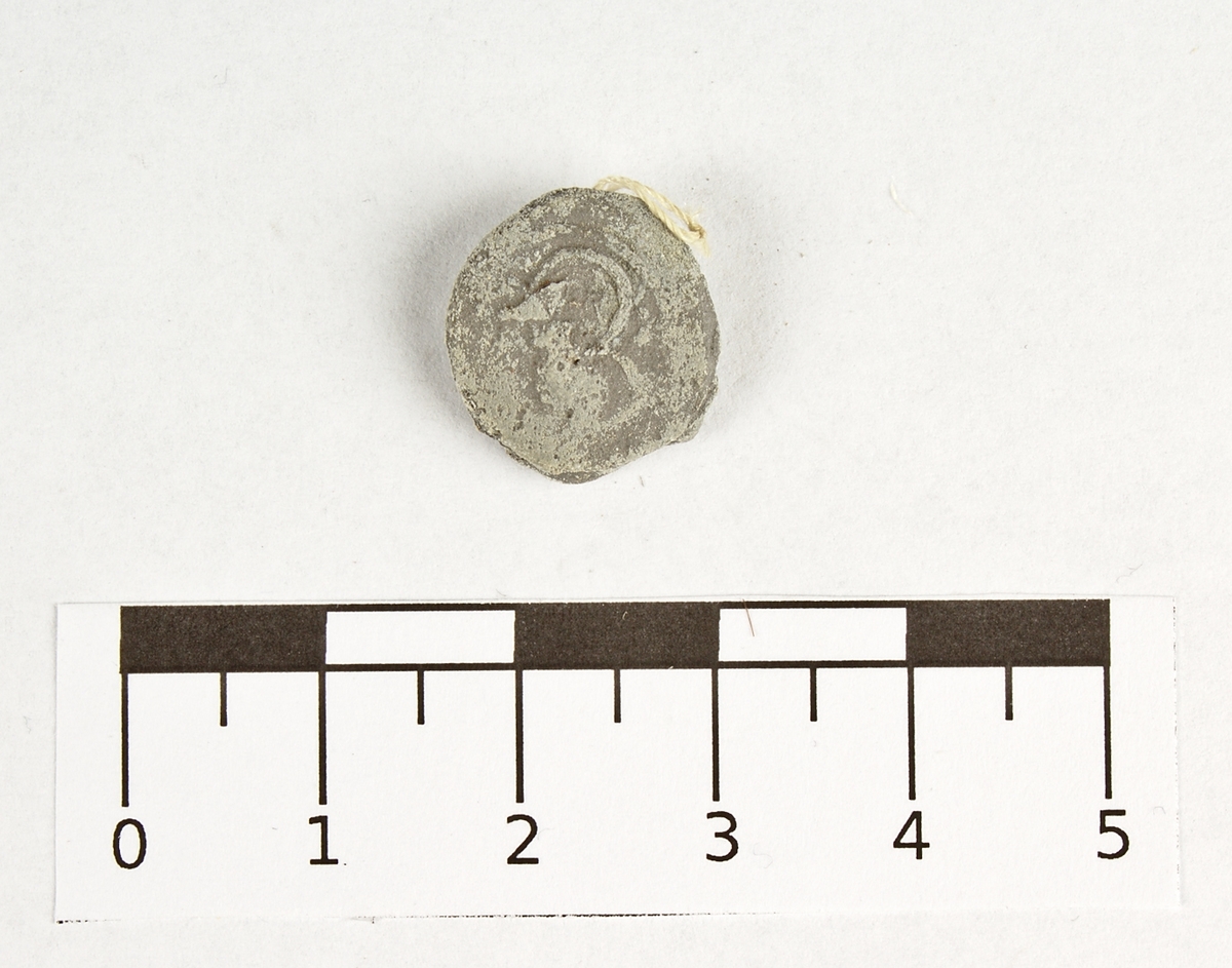 Blyplomb med spår av stämpel.