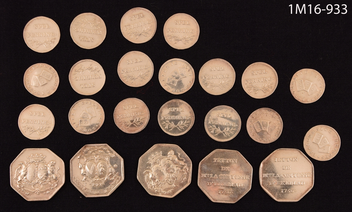 Fem stora och arton mindre spelpenningar av silver med grevinnan Ekeblads vapen, märkta 1756. Penningarna förvaras i en röd läderpung.