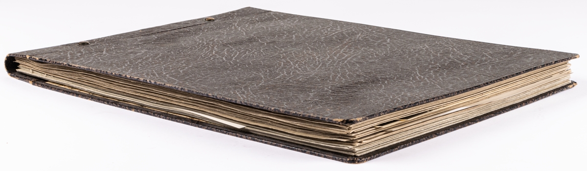 Fotoalbum innehållande skulpturer av Ida Matton. Inbunden läderpärm med pappsidor.