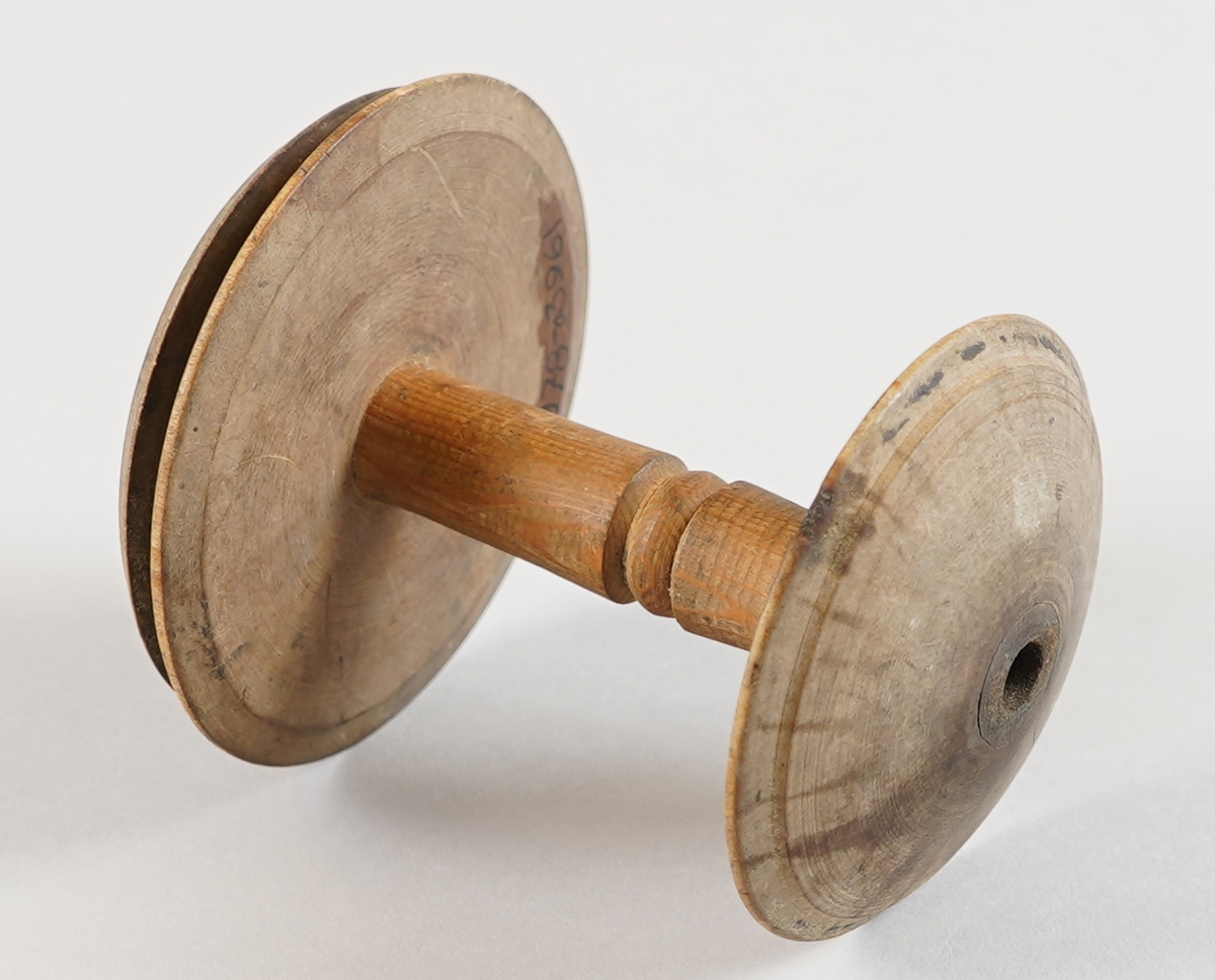 Snelle. Del av tein til hjulrokk. I tre. Dreia. Gjennomgåande hol. Ser brukt ut.