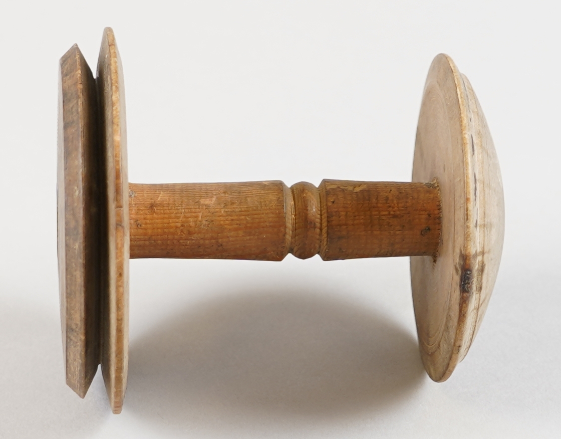 Snelle. Del av tein til hjulrokk. I tre. Dreia. Gjennomgåande hol. Ser brukt ut.