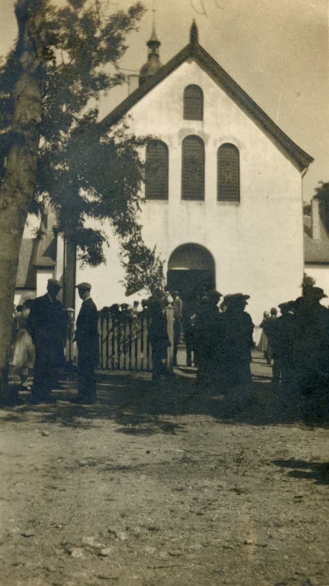 Motiv av ei gruppe mennesker utenfor Borgund Kirke.