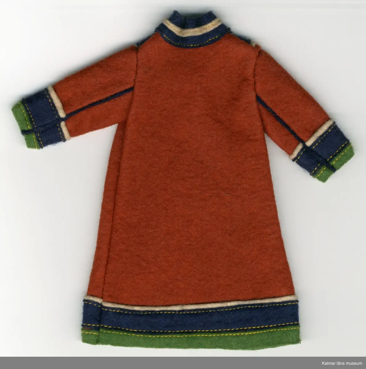KLM 28082:292:1-3 Samekolt, dockkolt, 3 stycken, av textil, ylle. Lång kolt, utan öppning, brun, med grön, mörkblå och vit garnering. Nertill på ärm och koltens fåll, tygränder, lodräta, vit, mörkblå och grön, i nämnd ordning. Längs ärm, två blåa ränder i tyg, passepoalsydda. Krage, blå, hög i nacke, med vit tygrand, framtill, v-krage, i grönt, blått och vitt tyg. Del av samisk nationaldräkt.