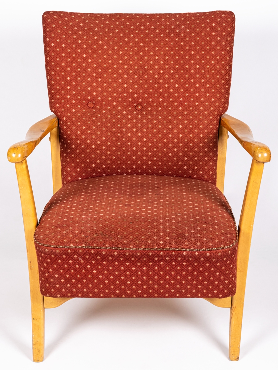 Katalogkort: Fåtölj. Ljust träslag i armstöd och ben. Sits och ryggstöd klädda med mönstervävt tyg. Varp: röd. Inslag: rett, vitt. Gåsögonliknande mönster. Sitsens kant, kantad med snodd i rött och vitt. På stolsryggens framsida fanns ursprungligen 3 textilklädda knappar, varav en saknas.

h 80cm, b 66cm, dj 77cm
