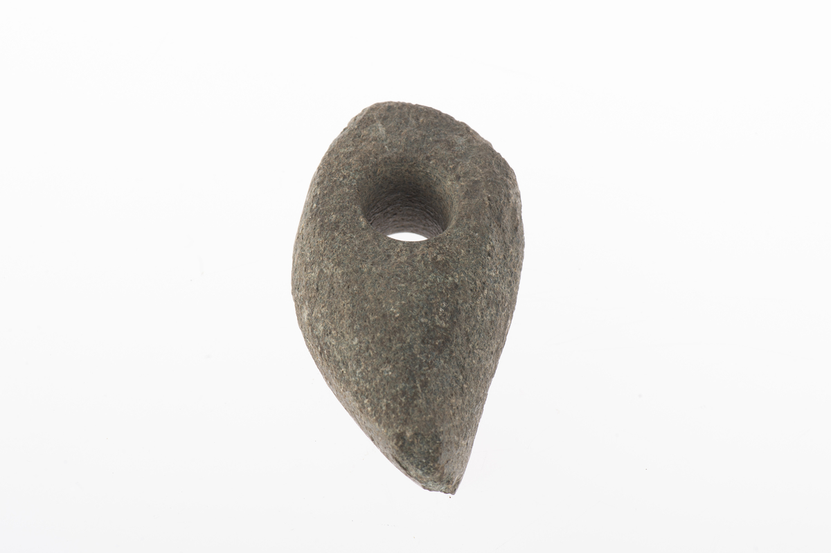 Liten, osymmetrisk. Eggen kraftigt snedvriden. Smalsidorna slipade mot eggen.