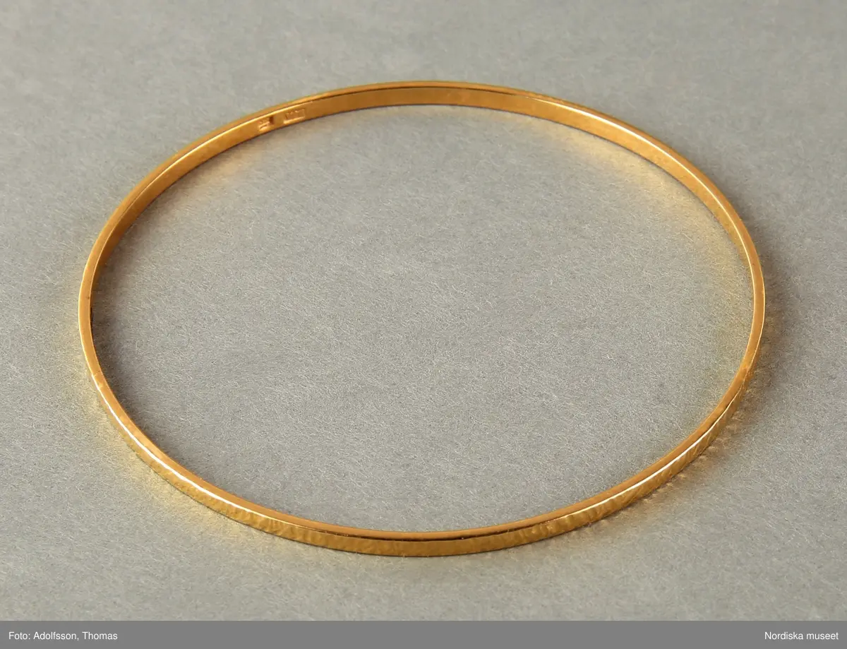 Armringar  i guld,  5 st = 2 st släta utan dekor (a-b), 1 st med dekor med tvärgående räfflor (c) och  2st  med hammrad dekor (d-e).
Samtliga armringar är stela samt utan öppning. Stämplade BJA 585. 


/Cecilia Wallquist 2019-02-15
