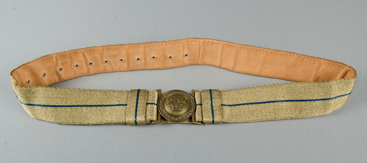 Uniform av diagonalvävt ylletyg. Guldgaloner och gradbeteckningar av gulmetall. Knappar av gulmetall med riksäpple. Fodrad med grått konstsiden. Skärp av brunt läder med axelrem. Skärp av metalltråd i guld och blått, läderfodrat, mässingsspänne. Uniformsmössa av grått kypertvävt ylle. Svart läderskärm, guldsnodd. Mässingsknapp och emaljkokard. Text: Arméns centrala beklädnadsverkstad. Skärmmössa med skärm av tyget. Båtmössa.