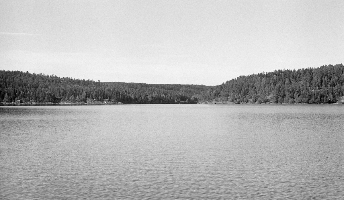 Glommas utløp fra Øyeren ved Mørkfoss, på grensa mellom Trøgstad og Spydeberg kommuner i Østfold.  Fotografiet er tatt fra båt, og viser ei vannflate med små krusninger, antakelig fra en lett bris.  Terrenget omkring vassdraget er bergfylt og bevokst med skog.  Det avbildete partiet var innfallsporten til nedre Glomma for alt tømmeret som ble slept over innsjøen fra Fetsund lenser med sikte på videre fløting mot Sarpsborg- og Fredrikstadregionen. Fotografiet skal være tatt 20. september 1984. 