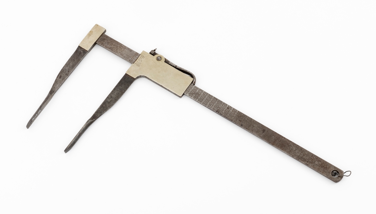 Skyveklave for diametermåling og volumberegning tømmer, altså en såkalt «kubikklave». Redskapet er lagd av stål. Det har en 52,3 centimeter lang, rett linjal med rektangulært tverrsnitt (2,4 X 0.4 centimeter). I den ene enden er det påtappet en rettvinklet 20,3 centimeter lang klavearm (målt langs innersida, 23,4 centimeter utvendig) som smalner noe mot ytterenden. Klaven har også en bevegelig arm med samme lengde og samme vinkling i forhold til linjalaksen. Denne armen er smidd sammen med en fal som tjente som handtak når den bevegelige klavearmen skulle posisjoneres under målingsarbeidet. På tverrenden av denne komponenten er det montert en fjærbelastet stålhendel, der endeleddet, ved hjelp av en vingemutter i den andre enden, kan låses i en bestemt posisjon, basert på tommemål på klavelinjalens tverrende. På den ene sida av aluminiumsdekselet på handtaket er romertallene IIIX, IIX, IX og X innstemplet. På den andre sida finner vi tallrekka XIV, XV, XVI, XVII og XVIII. Disse tallene refererer antakelig til relevante lengdemål på tømmerstokker, oppgitt i halvmetere. Ved å sammenholde disse tallene med tallrekker på klavelinjalens langsider kunne man lese av stokkvolumene, målt i liter. Den ene flatsida har også en diameterskala i centimeter, mens tommediametere avleses på linjalens tverrende. Alle mål avleses ved den bevegelige klavearmens innerkant. Ved bruk av diameterklave sparte tømmermålerne mye kontorarbeid med volumberegninger med utgangspunkt i lengde- og midtmål. Produsentens stempel er plassert på en av klavelinjalens ytterender.

Denne klavetypen skal være konstruert av Ole S. Øvergaard (1873-1945) fra Lillestu Koppang i Stor-Elvdal, som på dette tidspunktet var driftsbestyrer på Evenstad skogskole i Stor-Elvdal. Den ble mønsterbeskyttet i 1914. Bare de første kubikklavene hadde volumer angitt i hele liter, senere grovere inndeling.