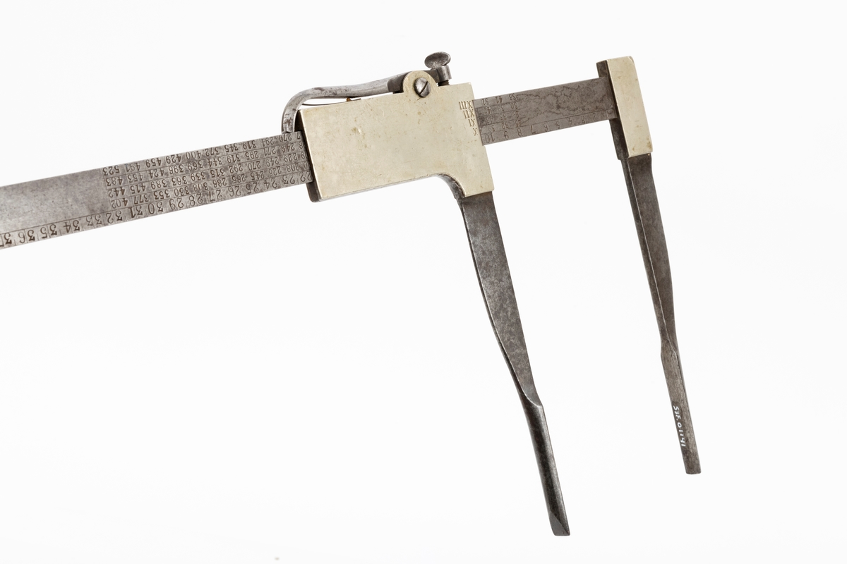 Skyveklave for diametermåling og volumberegning tømmer, altså en såkalt «kubikklave». Redskapet er lagd av stål. Det har en 52,3 centimeter lang, rett linjal med rektangulært tverrsnitt (2,4 X 0.4 centimeter). I den ene enden er det påtappet en rettvinklet 20,3 centimeter lang klavearm (målt langs innersida, 23,4 centimeter utvendig) som smalner noe mot ytterenden. Klaven har også en bevegelig arm med samme lengde og samme vinkling i forhold til linjalaksen. Denne armen er smidd sammen med en fal som tjente som handtak når den bevegelige klavearmen skulle posisjoneres under målingsarbeidet. På tverrenden av denne komponenten er det montert en fjærbelastet stålhendel, der endeleddet, ved hjelp av en vingemutter i den andre enden, kan låses i en bestemt posisjon, basert på tommemål på klavelinjalens tverrende. På den ene sida av aluminiumsdekselet på handtaket er romertallene IIIX, IIX, IX og X innstemplet. På den andre sida finner vi tallrekka XIV, XV, XVI, XVII og XVIII. Disse tallene refererer antakelig til relevante lengdemål på tømmerstokker, oppgitt i halvmetere. Ved å sammenholde disse tallene med tallrekker på klavelinjalens langsider kunne man lese av stokkvolumene, målt i liter. Den ene flatsida har også en diameterskala i centimeter, mens tommediametere avleses på linjalens tverrende. Alle mål avleses ved den bevegelige klavearmens innerkant. Ved bruk av diameterklave sparte tømmermålerne mye kontorarbeid med volumberegninger med utgangspunkt i lengde- og midtmål. Produsentens stempel er plassert på en av klavelinjalens ytterender.

Denne klavetypen skal være konstruert av Ole S. Øvergaard (1873-1945) fra Lillestu Koppang i Stor-Elvdal, som på dette tidspunktet var driftsbestyrer på Evenstad skogskole i Stor-Elvdal. Den ble mønsterbeskyttet i 1914. Bare de første kubikklavene hadde volumer angitt i hele liter, senere grovere inndeling.