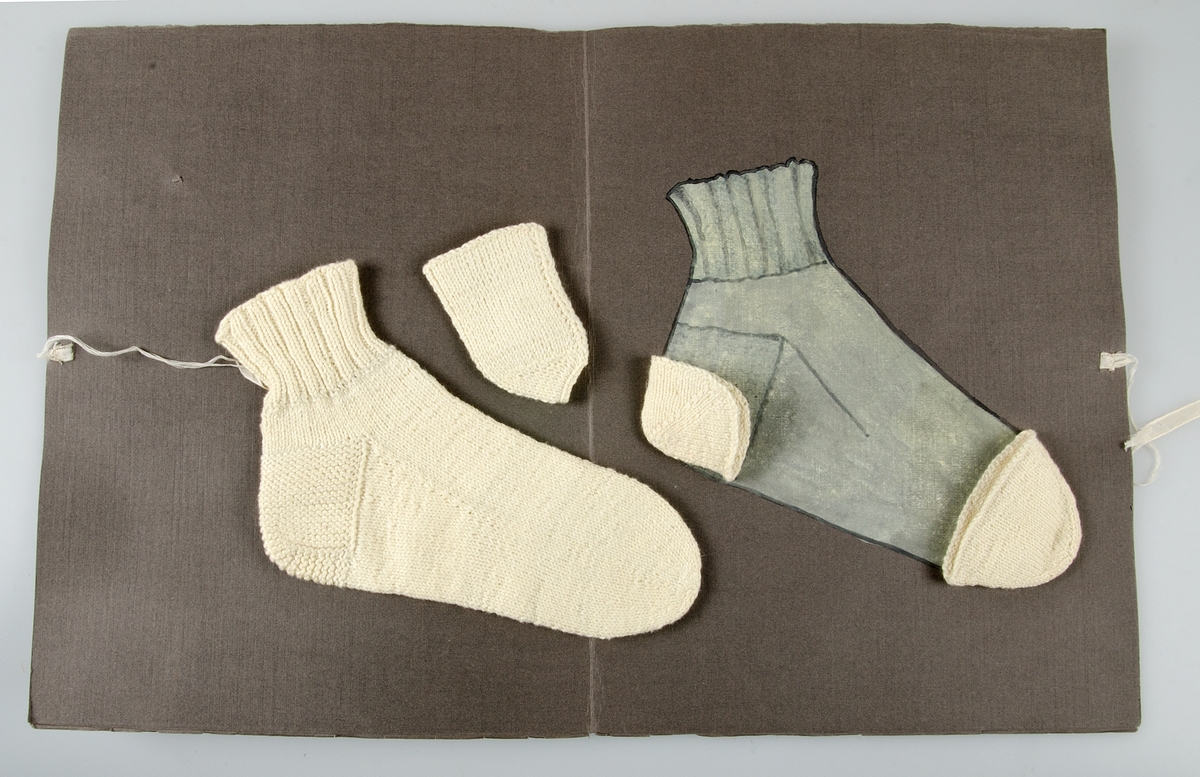 Stickad socka av oblekt bomullsgarn, samt tre stickade delar till strumpfot av oblekt bomullsgarn. Förvaras i en grå papperspärm, på framsidan texten: STRUMPFOT JUDIT JANSSON. På uppslaget en målad socka. Knytes med ljusa silkesband.