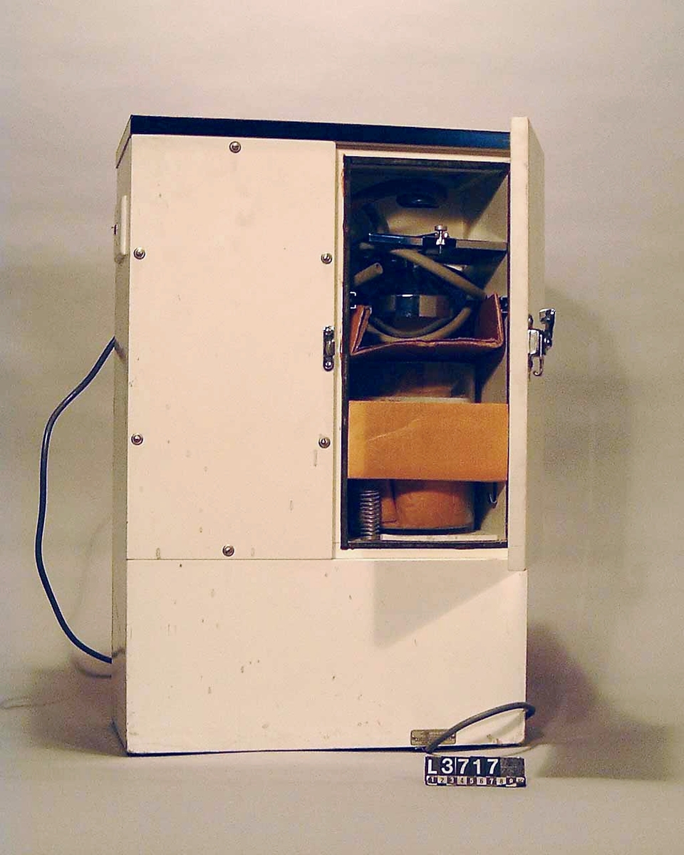 Dental Aspirator(salivsug) av märket Electrolux. Vit låda med måtten: 600 x 800 x  300 mm. Fram på salivsugen finns det två kromade krökar, på vilka man trär på slangarna till salivsugen. På sidan finns manövreringsknappar.