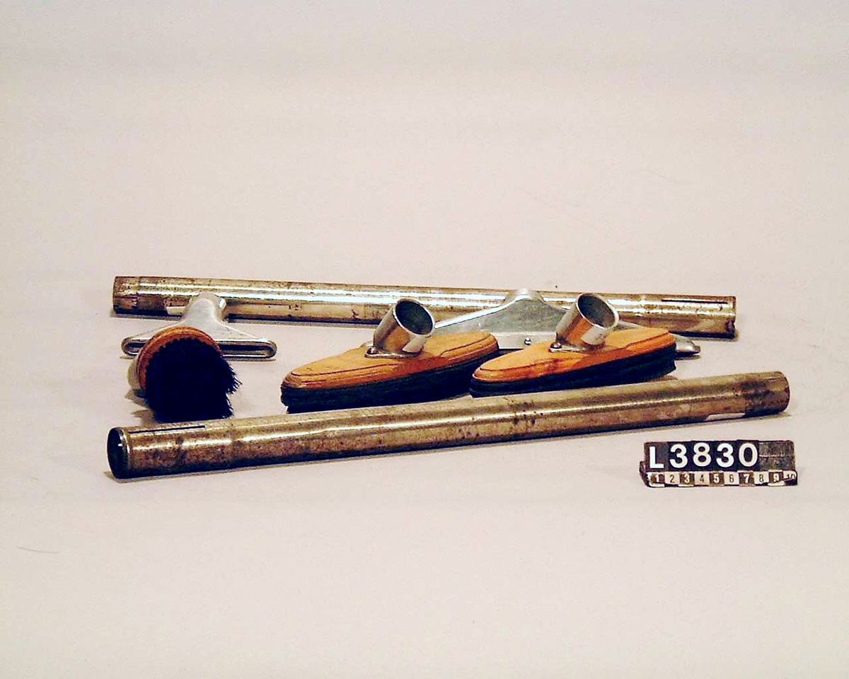 Cylinderdammsugare, klädd i guldaktig skimrande pegamoid. Fram och bakstycke samt medar i blank metall. Apparaten ligger i en koffert/väska. Under apparaten finns en etikett med Nr 30. Alla tillbehör finns, dock ej kabel. De kromade skarvrören är rostangripna.