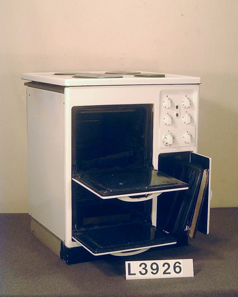 Spis med fyra plattor, ugn och värmeskåp. Överhäll och framsida är emaljerade, övrigt lakerad i benvit färg. Framsidan är heldragen, d.v.s. utan skarvar. Manöverorganen är koncentrerade till ett ställe på framsidan så att de blir lätt synliga uppifrån. Vred och luckhandtag av vit pressmassa. Överhällen är uppfällbar. Spisen står på en grålakerad socke som är försedd med hjul baktill. Alla plåtar finns.