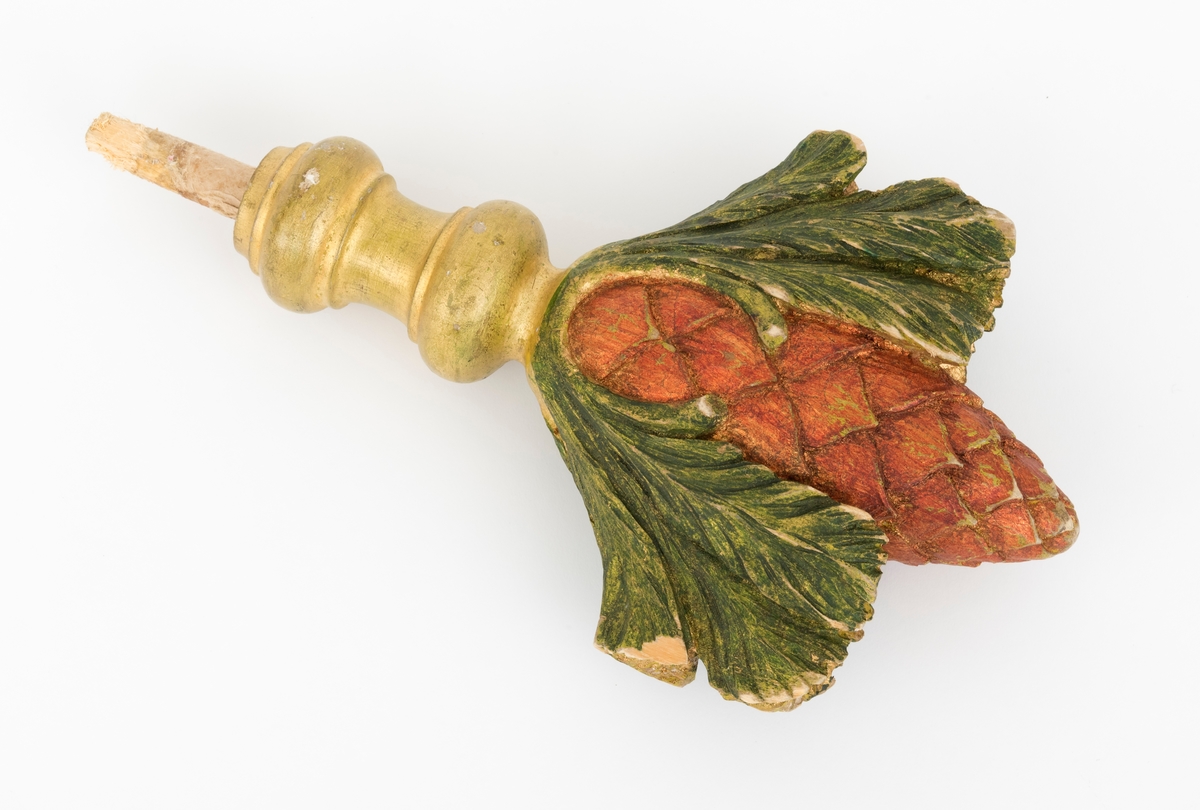 Spydet er formet som en kongle, og den tilhører fanen. Fanen har en tverrgående stang i toppen av fanen. På hver side av denne festes det et spyd i hver av endene.