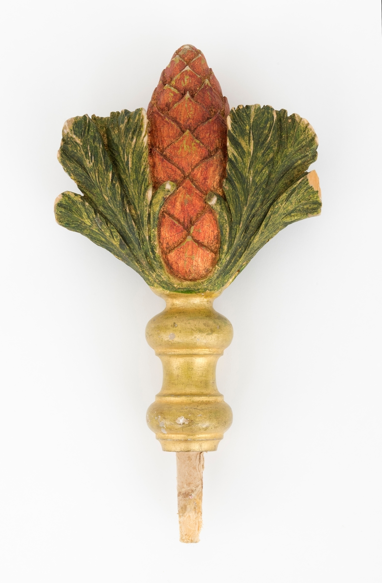 Spydet er formet som en kongle, og den tilhører fanen. Fanen har en tverrgående stang i toppen av fanen. På hver side av denne festes det et spyd i hver av endene.