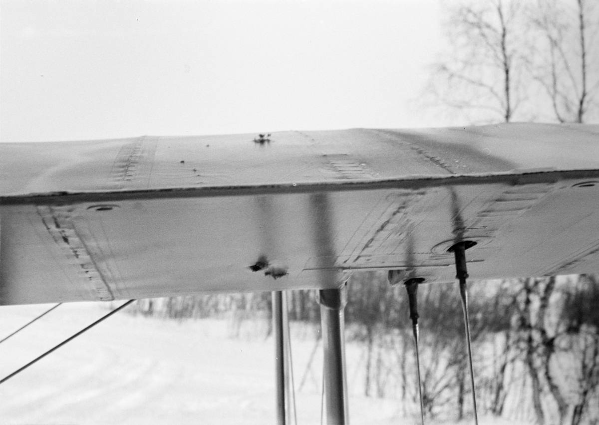 Kulhål i vinge på flygplan Gloster Gladiator gul J, efter beskjutning i luftstrid den 7 mars 1940. Vid F 19, Svenska frivilligkåren i Finland, 1940. Serie om 5 bilder.