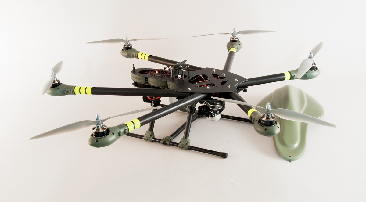 Drönare "Spyder 6" med sex motorer. Lyftkapacitet 9 kg, detaljer av plast, kolfiber och metall. Med styrelektronik från 3D Robotics, en STM32F4 microcontroller och Pixhawk open-hardware autopilot, en Mems-accelerometer för GPS, kompassriktning, acceleration. Digitalkamera Olympus PEN Light typ E-PL5 monterad under drönaren för vertikal fotografering. 
Batteriet var av typen Litium Polymer med 25,2V spänning fulladdat. Två parallellkopplade batterier användes för ökad flygtid. Ett batteri gav ca 15 min flygtid och två gav ca 20-25min.
Kameran startades med en impuls från autopiloten varpå den gjorde serietagningar under hela flygningen. Drönaren följde en inprogrammerad bana för att täcka in området. Bilderna går att betrakta som stereogram, användas för 3D-visualisering/rendering samt läggas samman till ett ortofoto.
Med drönarfilmer går det att skapa visualiseringar i tidiga skeden av ett byggprojekt. Det går också att beräkna volymer för schakt- och byggnadsmassor utifrån bilderna tagna från luften. Med ortofoto som grund går det att ta fram planeringar för byggprocessen. Drönarfotograferingen är effektiv för den kostar inte mycket och täcker snabbt in stora områden. Tekniken förbättrar arbetsmiljön för mättekniker som tidigare mätt upp land för hand.