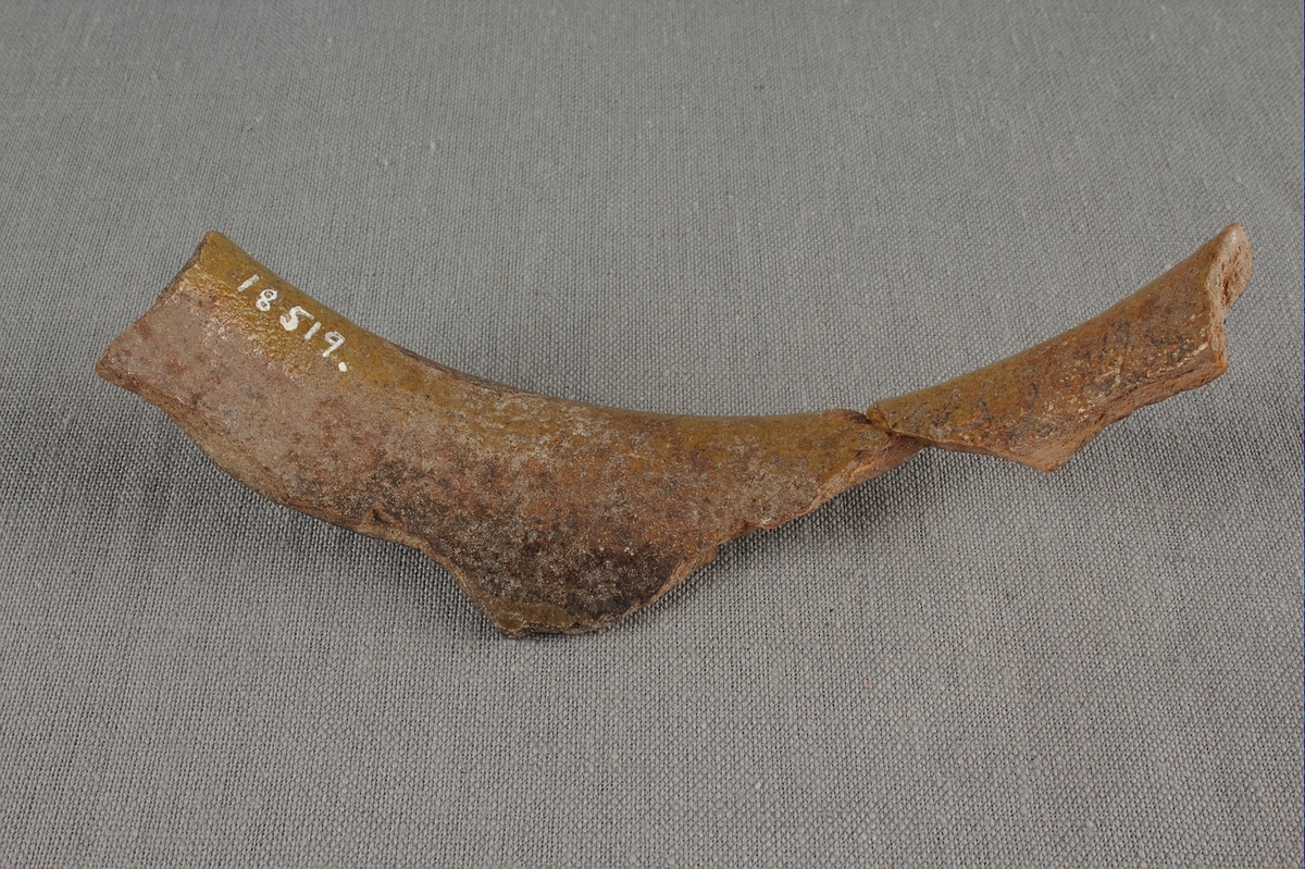 Skärva av drejat och glaserat lergods. Del av överkanten från ett kärl. Insidan av kärlet är glaserat i brunt.

Mynningen på kärlet beräknas ha haft en diameter på omkring 15cm.