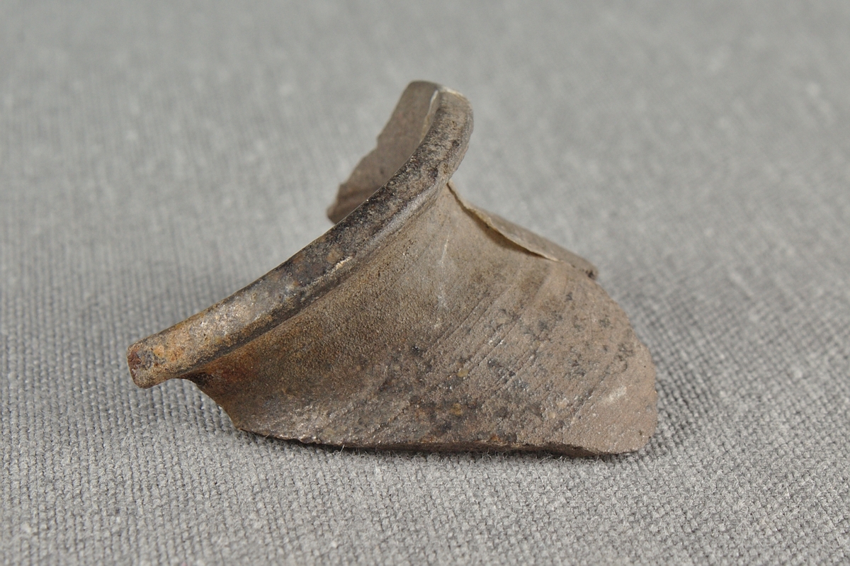 Skärva av drejat lergods. Del av en överkant från ett kärl.