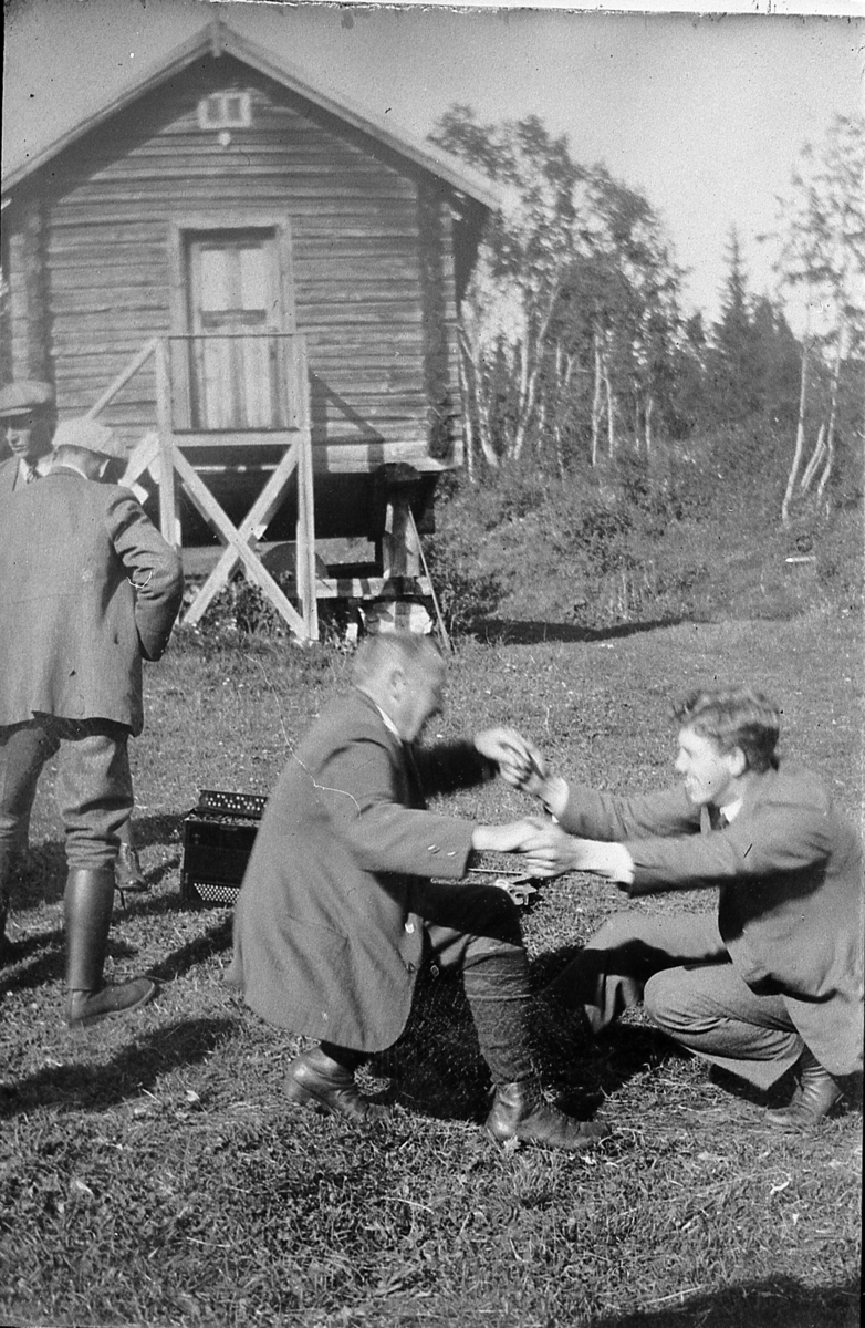 Ukjente menn i lystig lag, i gang med "kruking". På Mosebekk, Øvre Eiker, før 1940.