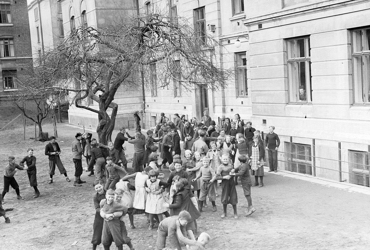 Svart-hvitt foto av ungdommer som leker i en bakgård.