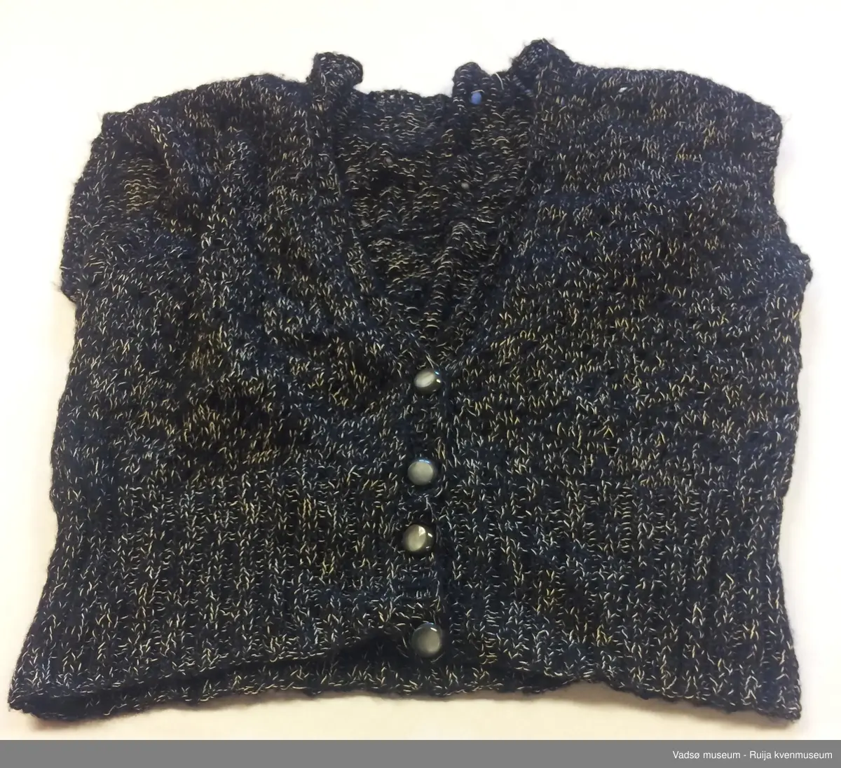Svart strikkevest for dame. Vesten lukkes igjen med fire knapper på framsiden.