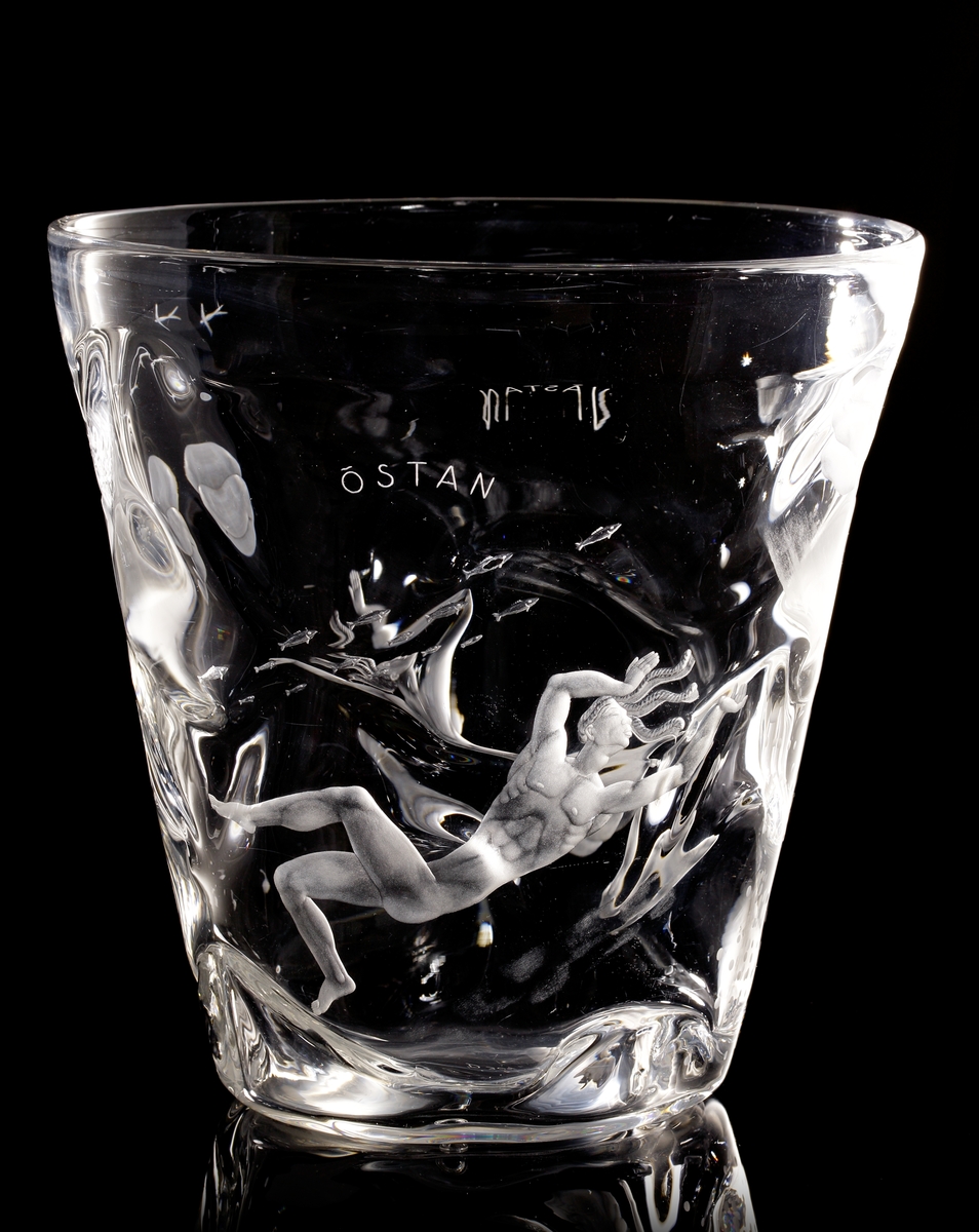 Skål "De fyra vindarna" av Vicke Lindstrand, med graverat motiv av de fyra vindarna Sunnan, Östan, Nordan, Västan, personifierat av två nakna män och två nakna kvinnor, tillsammans med inslag av motiv från flora och fauna.