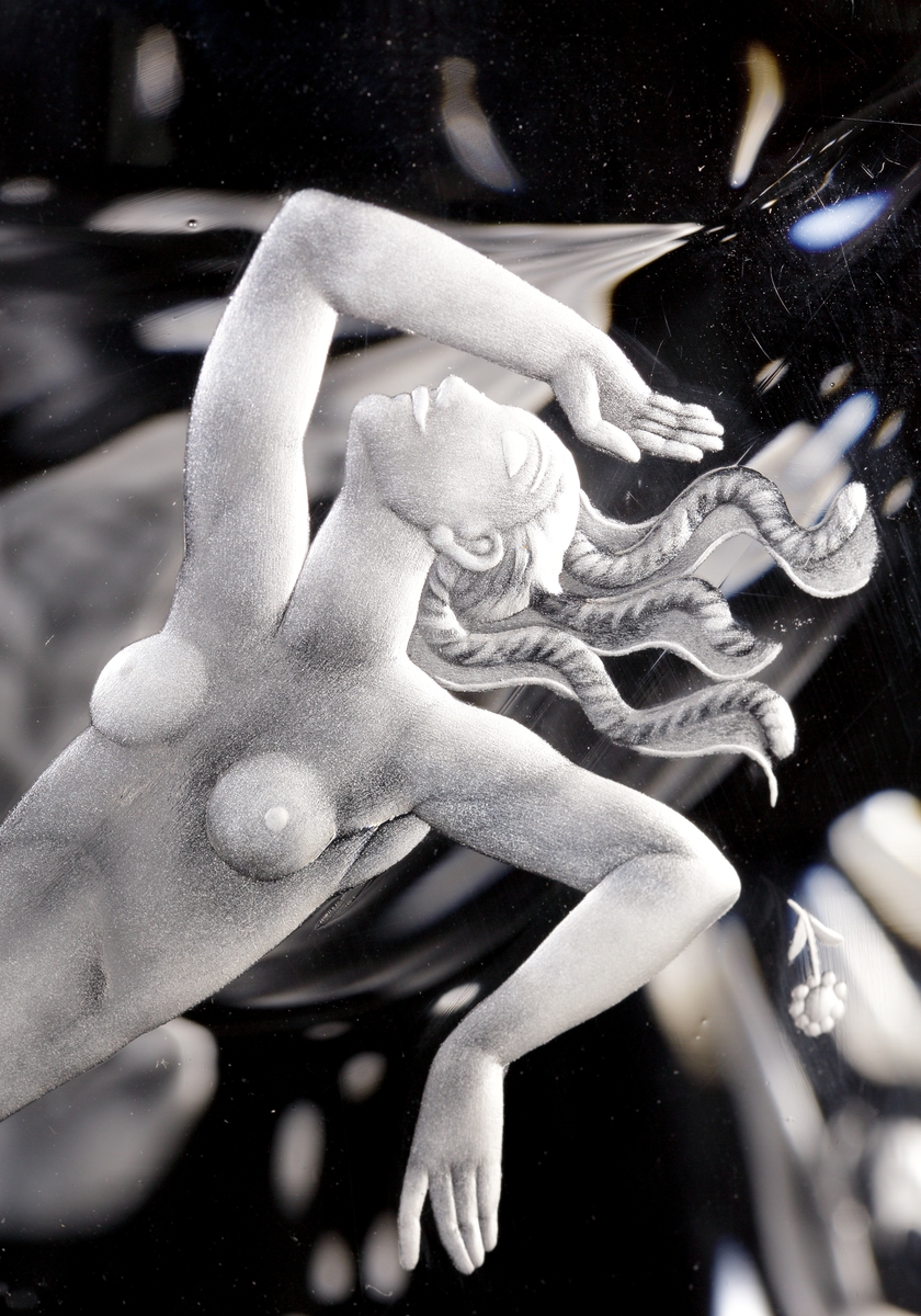 Skål "De fyra vindarna" av Vicke Lindstrand, med graverat motiv av de fyra vindarna Sunnan, Östan, Nordan, Västan, personifierat av två nakna män och två nakna kvinnor, tillsammans med inslag av motiv från flora och fauna.