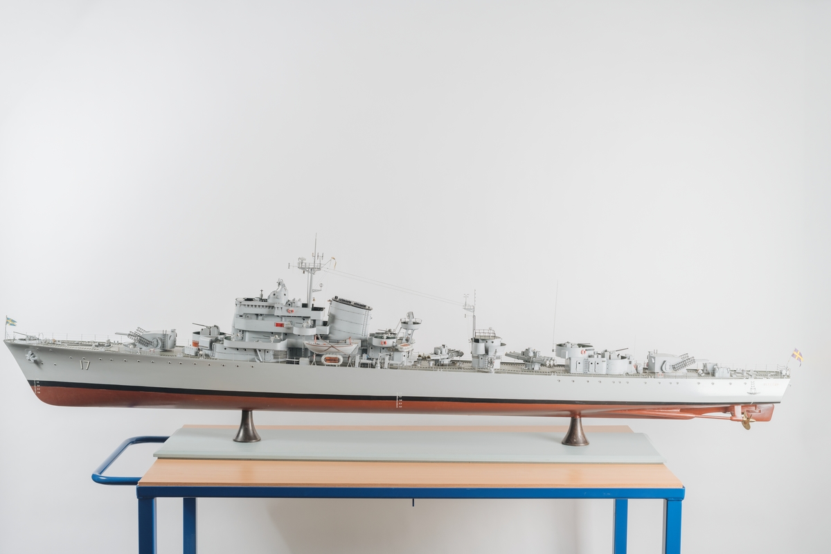 Helmodell av jagaren Uppland i ursprungligt skick. Bestyckad med 12 cm kanoner, luftvärn, torpeder samt sjunkbomber Skrovet är tillverkat i trä och gråmålat med detaljer utförda i metall. Modellen är i skala 1:50.
Stativet utgörs av två metallpelare.