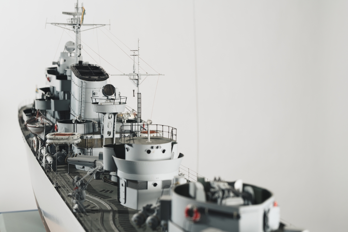 Helmodell av jagaren Uppland i ursprungligt skick. Bestyckad med 12 cm kanoner, luftvärn, torpeder samt sjunkbomber Skrovet är tillverkat i trä och gråmålat med detaljer utförda i metall. Modellen är i skala 1:50.
Stativet utgörs av två metallpelare.