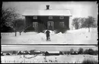 Pojke framför hus