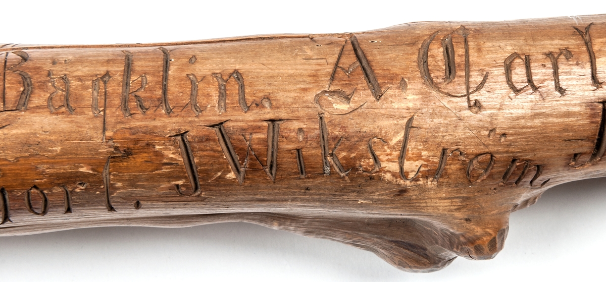 Spatserkäpp, knölpåk, av ene, med att stort antal gävlenamn inristade, flera av dem med studentexamen under 1870-talets första år. 
Käppen är daterad: Kullerhamn och Granskär 27/7 1873.
Namn:
A. Petersson
E. Höjer
A. Nygren
C. Klintberg
F. v. Schéele
A. Ölund
D. Carlsson
O. Nordin
G. Holmström
E. Östman
C. Almgren
A. T. U. Ohlsson
R. Bäcklin
K. G. Hjort
A. Carlsson
J. Wikström
A. Lundeberg
J. Hedeström
W. M. Fröstedt (Wilhelm Mauritz)
F. Sundberg
G. Sandlund