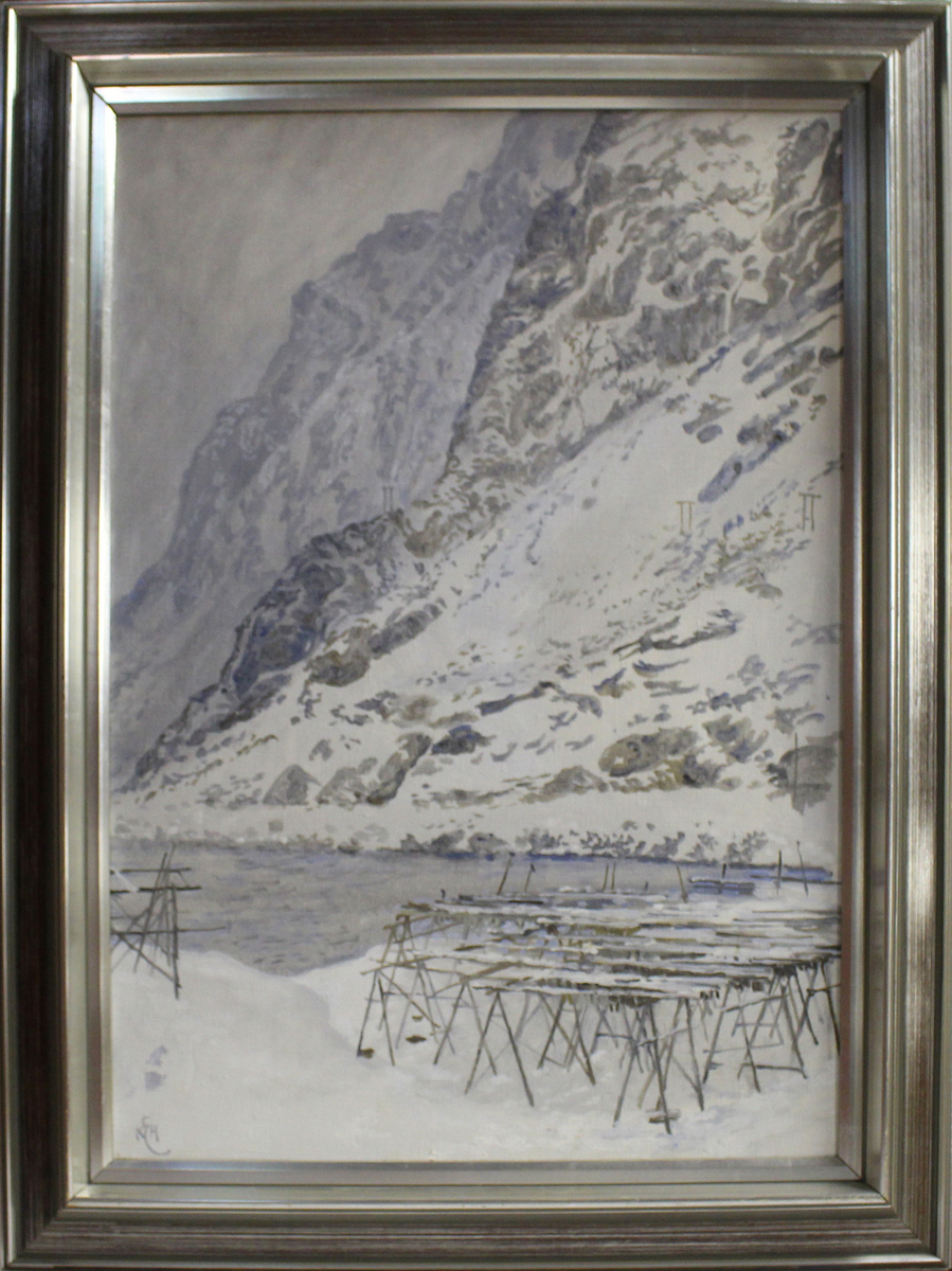 Vinterlig landskap med bratte fjellsider og hav. Fiskehjell sees i forgrunnen. 