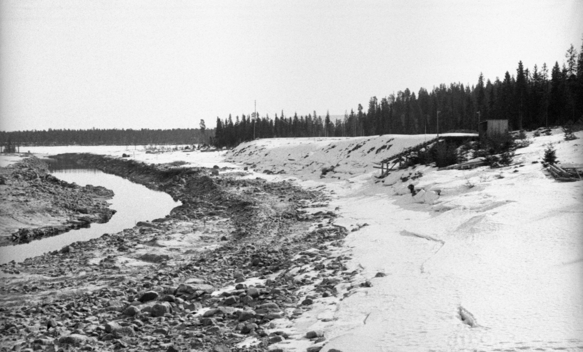 Det kanaliserte løpet fra Valmstjernet mot Osdammen i den nordvestre enden av Osensjøen i Åmot, fotografert i 1941.  Hensikten med dette prosjektet var antakelig å lette forholdene for fløtinga mot Osdammen.  Arbeidet ble antakelig gjort vinterstid på grunn av den lave vannstanden.  Masse fra djupålen i vassdraget later til å være flyttet opp på kantene.  Det var ingen anleggsmaskiner på stedet da dette fotografiet ble tatt, men det er rimelig å anta at det må ha vært brukt bulldoser i dette prosjektet.
