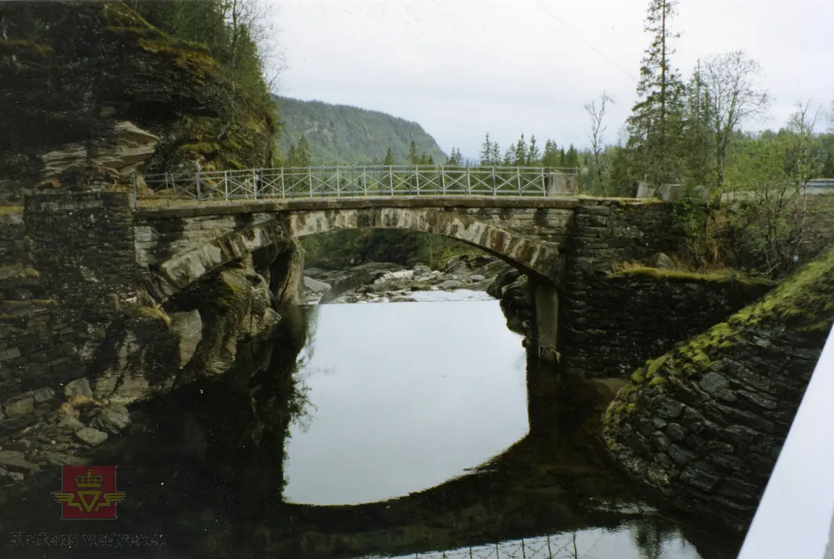 Fv12. Rødlielv steinhvelvbru ved Utskarpen i Rana. "Fredet." Gammel bru bygd 1911 - ny bru bygd 1957. Følg pilen til høyre.