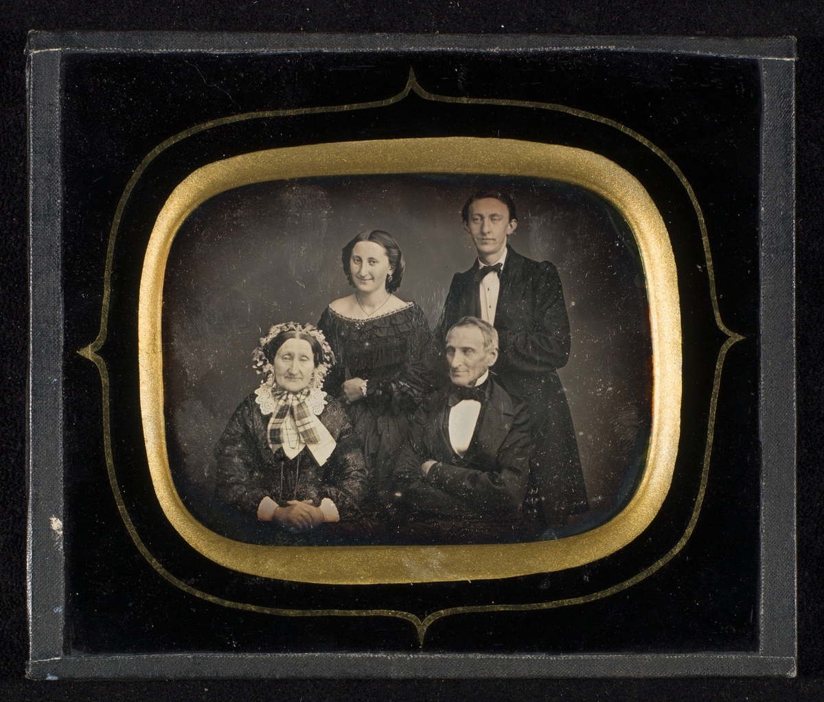 Daguerreotypi av eldre mann og kone. Ung kvinne og mann står bak dem.