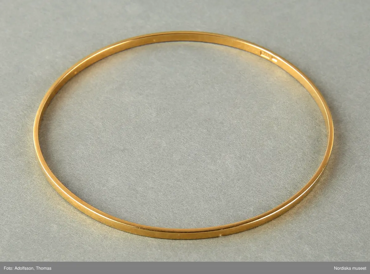 Armringar  i guld,  5 st = 2 st släta utan dekor (a-b), 1 st med dekor med tvärgående räfflor (c) och  2st  med hammrad dekor (d-e).
Samtliga armringar är stela samt utan öppning. Stämplade BJA 585. 


/Cecilia Wallquist 2019-02-15