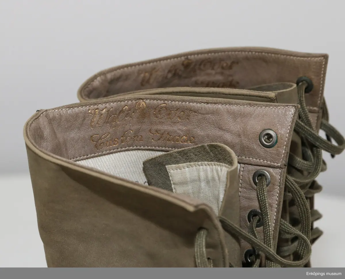 Grönbeige snörkänga för dam av mocka med taxklack.
Tillverkare: Walk Over. Märke: Custom Grade.
Inköpta i Amerika av givarens far Bele Nyström 1916/17. Storlek 38.