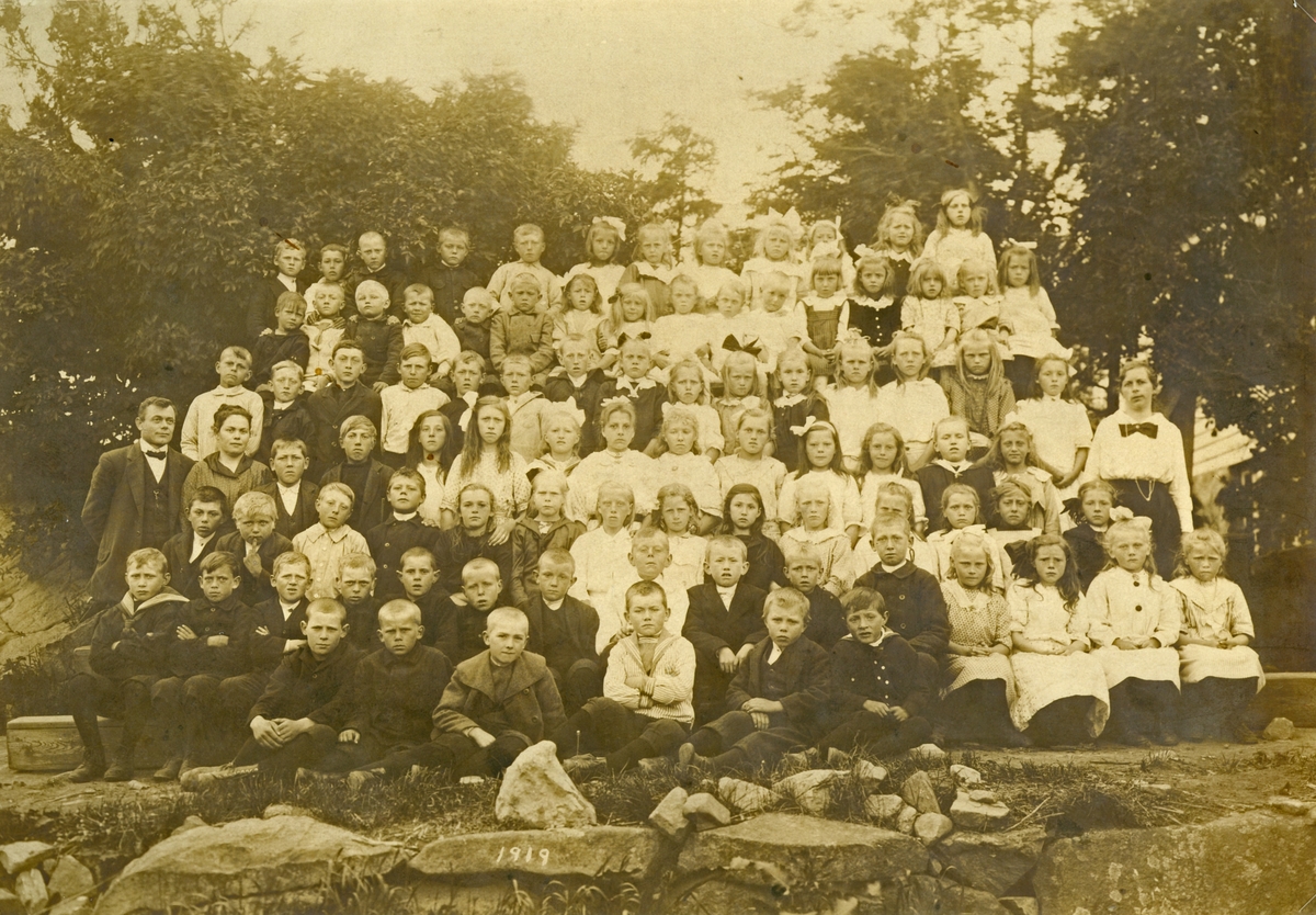 Lærere og elever på Sævland skole 1919. Poserer med trær i bakgrunnen. Totalt 93 personer.

Rekke 1 fra venstre: Kristoffer Tveit, Oluf Nilsen, Harald Kristiansen, Gabriel Stangeland, Peder Halvorsen og Trygve Mannes.
Rekke 2 fra venstre: Harald Mannes, Karl Olsen, jakob Jakobsen, Torgeir Brogeland, Johannes Tveit, Lars Davidsen, Hans, Karl Aanensen, Gustav Mandiussen, Olav L. Mannes, Peder Mannes, Gerda Pedersen, Olga Mikkelsen, Beate Stangeland og Linda Lund.
Rekke 3 fra venstre: Josef Halvorsen, Jakob Lund, Jørgen Sevland, Jonas Gundersen, Agnes Mannes, Karina Mannes, Malene Mannes, Grete Nilsen, Margit Egeland, Olina Øygarden, Ågot Aanensen, Åsa Hyland, Gurine Sivertsen og Elen Sivertsen.
Rekke 4 fra venstre: David Størkersen (lærer), Janna (fru Størkersen), Lars Rangvaldjord, Jakob Varne, Klara Mannes, Gunda Sevland, Ragna Mannes, Gerda Mannes, Serina Stangeland, Elen Aanensen, Gudrun Sevland, Tora Tveit, Elen Mandiussen og Elen Mannes.
Rekke 5 fra venstre: Knut Mannes, Endre Sevland, Villas Mannes, Lars Mannes, Nils Botn, Torfinn Torsen, Lina Brogeland, Inga Rasmussen, Anna Thorsen, Ida Mandiussen, Bergit Kristiansen, Olava Nyland, Gjertrud Lund, Ragna Larsen og Anna Årrestad.
Rekke 6 fra venstre: Kristoffer Olsen, Bendik Stangeland, David Lund, Torkel Egeland, Gunvald Øygarden, Magnus Årøy, Olga Rasmussen, Berta Årøy, Ragnhild Munkejord, kristian Munkejord, Roy Jonsen, Vivian Jonsen, Serina Tveit, Malena Larsen, Kitty Øygarden og Helga Sevland.
Rekke 7 fra venstre:  Gabriel Jakobsen, Peder Egeland, Ludvig Jakobsen, Magnus Sevland Gundersen, Asbjørn Sevland, Hilda Mannes, Talla Størkersen, Anna Rasmussen, Karry Mannes, Ida Tveit, Elisabeth Mannes og Ragnhild Varne.